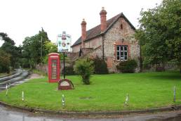 Village green, village sign and village hall in rural England