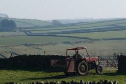A farmer driving a tractor in rural England